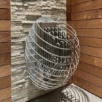 Wall-mounted HUUM Drop heater in a Scandinavian-style cedar sauna