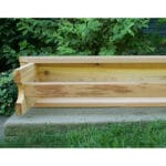 Cedar 1805 Bench in backyard placement, emphasizing natural amber finish and heavy-duty capacity of 690 lbs in this classic wooden bench outdoor