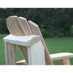 Side profile of sturdy Cedar American Forest Adirondack Chair, highlighting contoured seat, honey-brown tone, and forest-inspired design in this unfinished wood furniture piece.