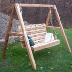 Romantic country-style Cedar Porch Swing w/Stand by Creekvine Designs, made of durable Western Red Cedar wood furniture with high-back contoured seat and rust-resistant hardware.