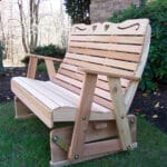 Close-up of heart and scroll details on Cedar Royal Country Hearts Rocking Glider backrest, emphasizing craftsmanship and rounded edges in resilient wood glider rocker.