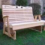 Cedar Royal Country Hearts Rocking Glider in terrace setting, showcasing amber facade and heart motifs as a soothing wood glider rocker for yards.
