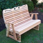 Side profile of durable Cedar Royal Country Hearts Rocking Glider, highlighting smooth gliding mechanism, scroll accents, and contoured seat in this wood glider rocker.
