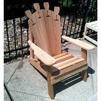 Close-up of wine glass holder on Cedar Adirondack Chair armrest, emphasizing practical design and smooth grain in resilient wood outdoor furniture.