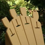 Side angle of durable Cedar Wine Glass Adirondack Chair, highlighting weather-resistant build, wine slot on arm, and contoured seat in this wood outdoor furniture