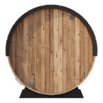 Evening photo of SaunaLife Elegance 6 outdoor barrel sauna with warm glow
