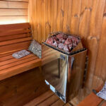 Premium SaunaLife E7G barrel sauna glowing at night with interior lighting