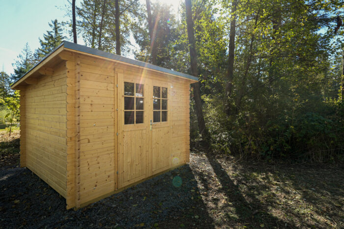 Wooden outdoor storage shed for cabin and rural property use